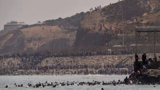 Jornada de caos: miles de personas migrantes cruzan la frontera de Ceuta para llegar a España